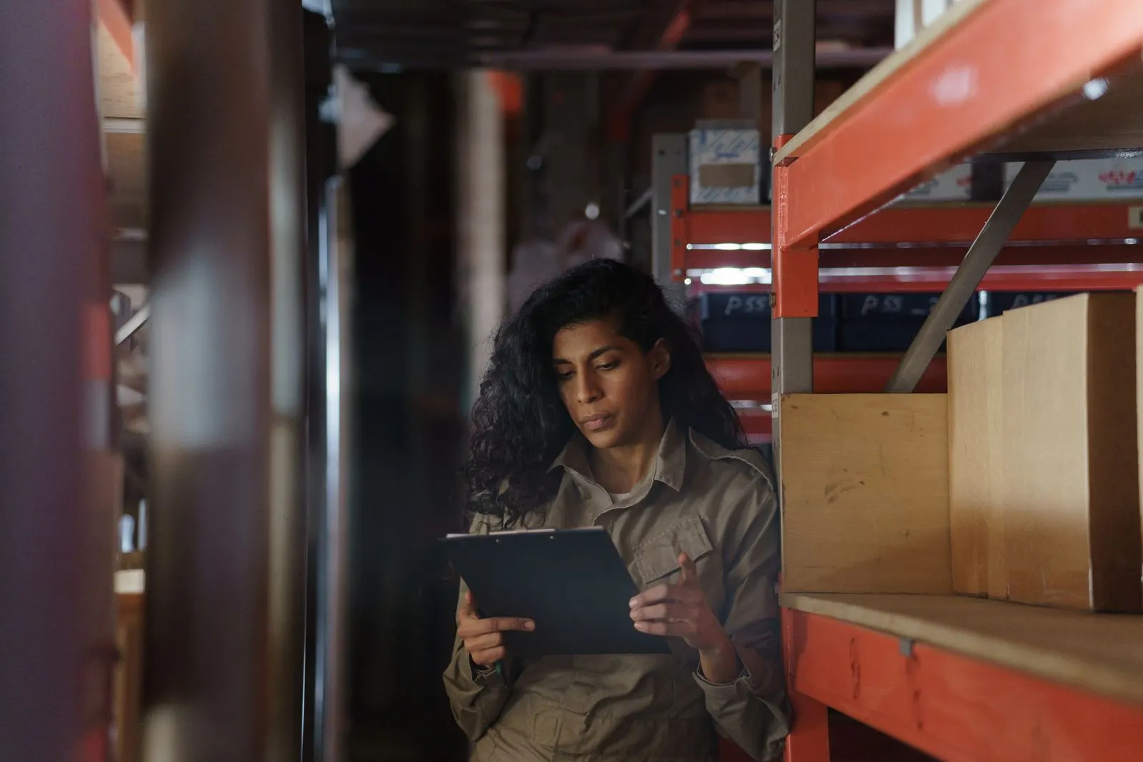 Une opératrice contrôle un stock sur tablette dans un entrepôt